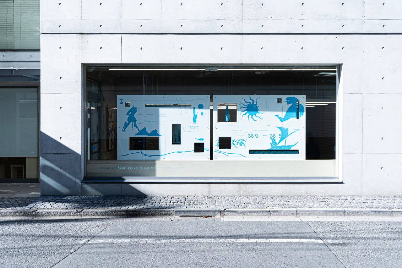 Modern storefront window display with blue and white graphic illustrations of figures and animals on light panels set into a minimalist black frame