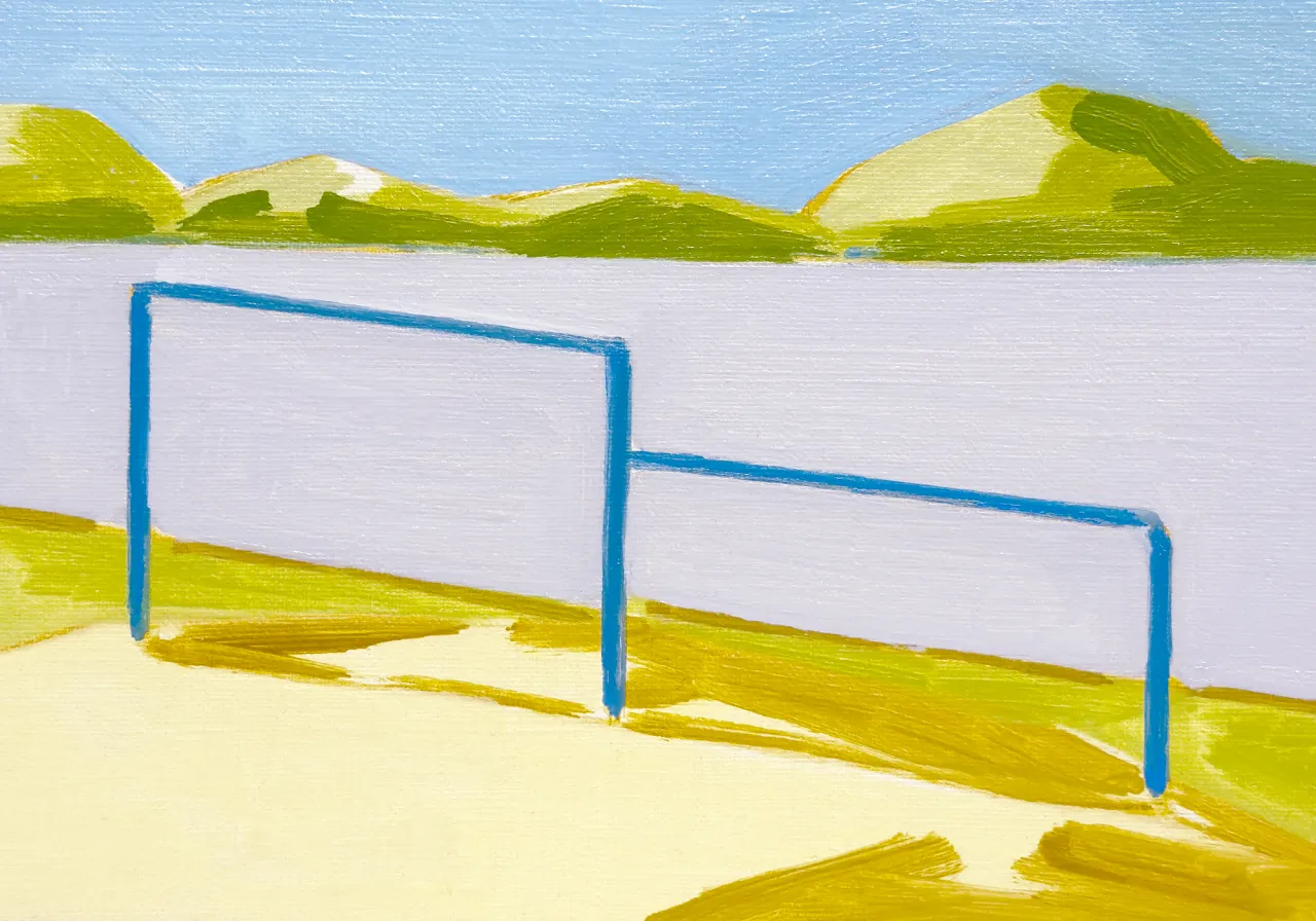 Blue metal goalposts in a grassy field with rolling green hills and blue sky beyond