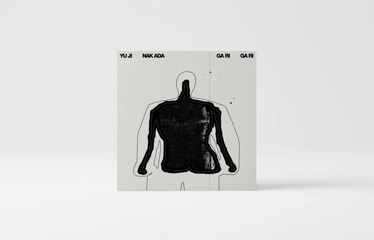 A beige book cover with a black silhouette of a torso and head against a light background, with Japanese text at the top reading Yui Nakada, Gari, Gari